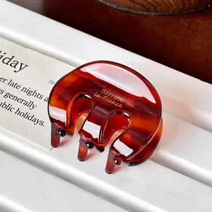 French style tortoise shell claw clip with Barrette La France gold lettering on white book