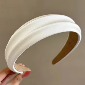 Elegant cream padded satin headband with a smooth silk texture for high cranial top style