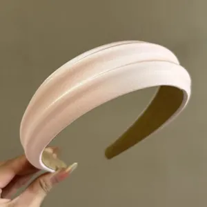 Detail of pink satin padded headband with premium silk luster and non-slip lining