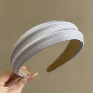 Detail of light blue padded headband with shiny satin fabric and non-slip inner lining