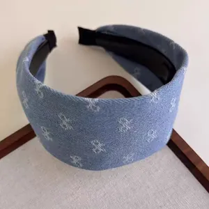 Detail of blue denim headband with white bow prints and non-slip inner lining