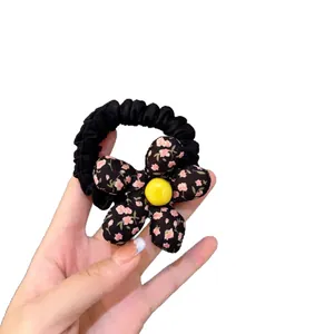 Sweet floral fabric hair tie with pink flower pattern and yellow decorative bead center