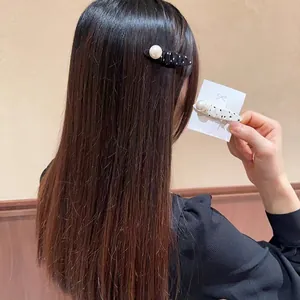 Polka dot fabric hair clips with pearl detail in black and white styles for women