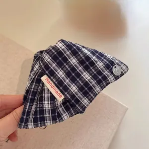 Navy blue checkered fabric hair claw clip with handmade tag shown in hand