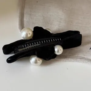 Velvet banana hair clip featuring white pearls and elegant black ribbon finish