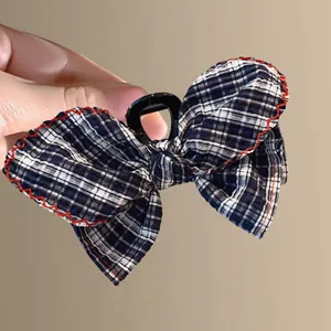 Classic navy plaid fabric bow hair claw clip with red wavy stitching and sturdy grip
