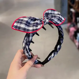 Detail of blue plaid bow headband with red piping and non-slip toothed inner grip