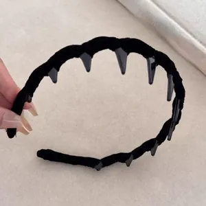 Dettaglio dei denti interni e della texture in velluto nero di questa fascia per capelli
