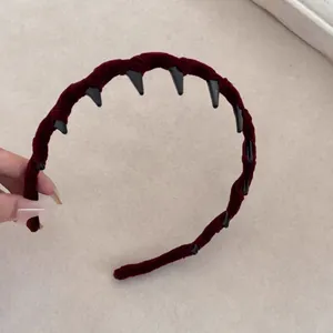Dettaglio del cerchietto in velluto bordeaux con denti antiscivolo per una tenuta sicura