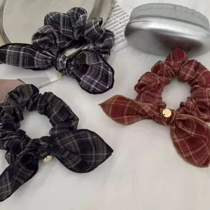 Set of three plaid bow scrunchies in black, blue, and red with gold metal charms