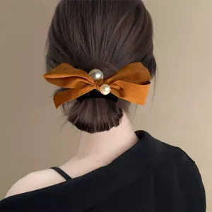Caramel suede bow hair clip with faux pearls shown on a high ponytail for elegant styling