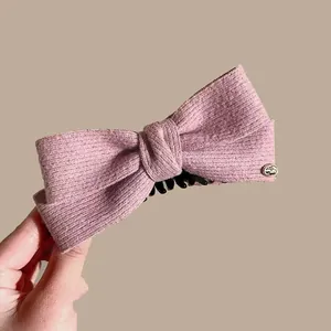 Dusty pink wool bow banana clip with golden metal emblem for high ponytail hairstyles