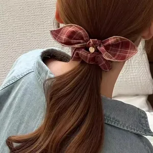 Retro red plaid bow hair scrunchie with gold charm on a ponytail with a denim shirt