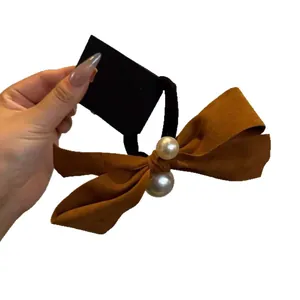 Velvet bow hair tie with pearls in caramel brown for elegant ponytail styling