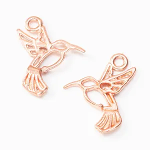 Two rose gold hummingbird jewelry pendants with hanging loops for DIY crafts