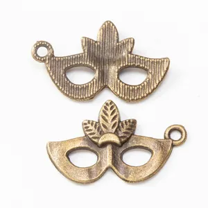 Vintage bronze mask charms for jewelry making with front and back detail views