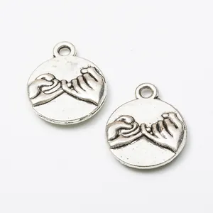 Vintage silver alloy round pendant featuring embossed pinky swear design on white background