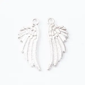 Macro detail of silver angel wing charms showing fine feather texture and metal loops