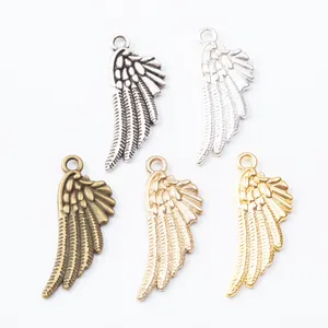 Vintage zinc alloy angel wing pendants in five metallic finishes on white background