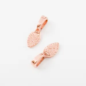 Detail of rose gold alloy pendant charms featuring hammered texture and leaf shape design