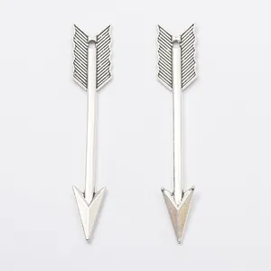 Vue macro de deux pendentifs flèche en argent avec textures de gravure vintage détaillées
