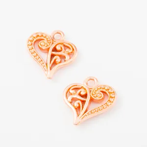 Close-up of two rose gold heart-shaped hollow metal charms for DIY jewelry making