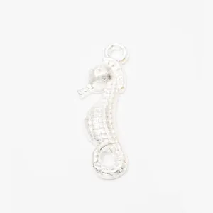 Detailed macro view of silver seahorse pendant with scales and circular hanging loop