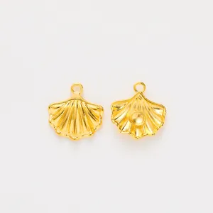 Detail of two gold scallop shell charms with fine radial texture and pearl mountings