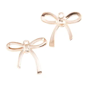 Golden vintage zinc alloy bow pendants for DIY jewelry making on white background