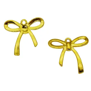 Detail showing two vintage gold bow charms with glossy metallic finish for DIY jewelry