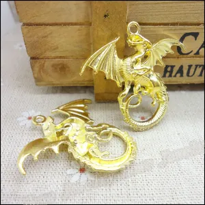 Macro shot of two golden zinc alloy dragon pendants on a rustic wooden craft box