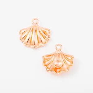 Macro detail of rose gold shell pendants with wavy texture and mounting rings for DIY jewelry