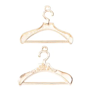 Detalle de dos colgantes de percha vintage en aleación de oro claro para joyería DIY