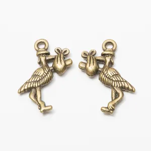 Antique bronze stork bird pendants with feather details and hanging holes for DIY jewelry