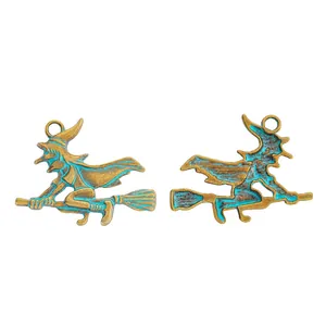 Detail of vintage bronze witch on broom pendants with blue enamel for DIY jewelry
