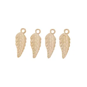 Macro detail of four gold leaf-shaped metal pendants with textured veins and top hanging loops