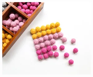 Macro shot of colorful wool felt pom pom balls in various vibrant colors for DIY crafts