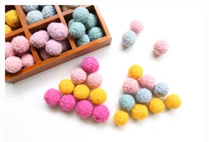 Detailed view of colorful handmade wool felt balls for DIY hair accessories and crafts