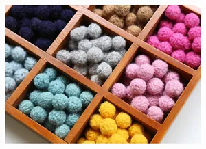 Macro view of colorful wool felt balls in a wooden organizer for DIY crafts and earrings