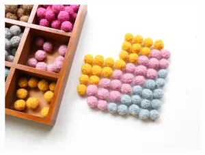 Colorful wool felt pom-poms arranged in a heart shape for DIY crafts and jewelry