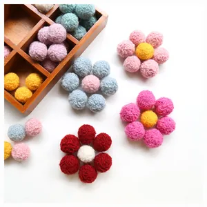 Colorful handmade wool felt pompom balls in flower shape and wooden storage box for DIY crafts