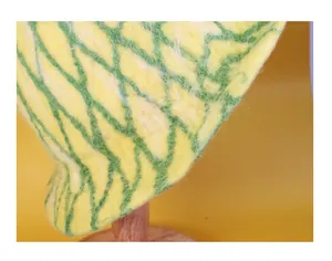Detailed close-up showing the green wavy texture and wool felt fiber of the pineapple hat