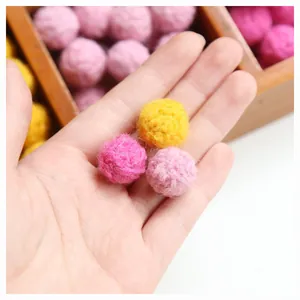 Handmade colorful wool felt balls for DIY earrings and craft accessories shown in hand