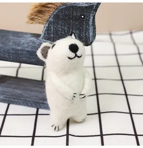 Detail view of handmade wool felt polar bear doll with soft fiber texture and cute face