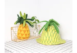 Detail of handmade wool felt pineapple hat and decor on a checkered tablecloth