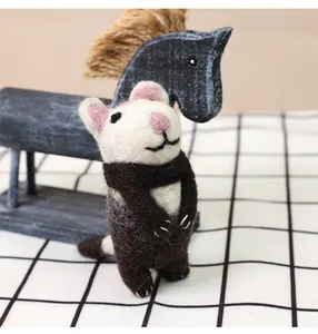 Close-up of handmade wool felt mouse doll with scarf showcasing soft fiber texture