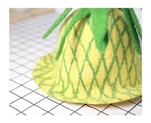 Detailed macro view of pineapple wool felt hat showing green leaves and diamond texture