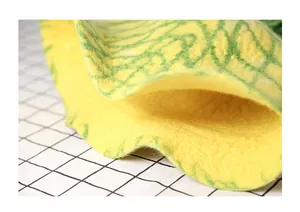 Detailed close-up of handmade wool felt material with green mesh texture on yellow pineapple hat