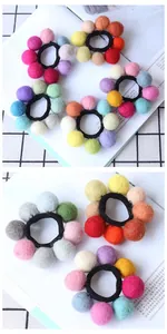 Detail of colorful handmade wool felt ball elastic hair ties in a soft flower arrangement