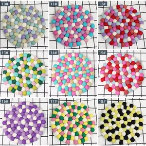 Detail view of handmade wool felt ball coasters in nine colorful multi-color patterns